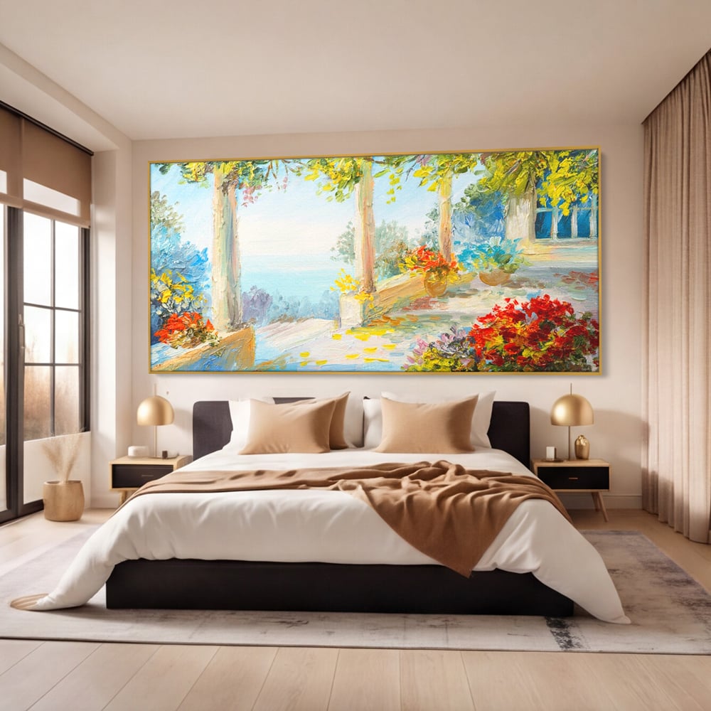 Tablou canvas cu pictura terasa insorita cu flori rosii, in rama de aluminiu auriu, pe perete intr-un dormitor
